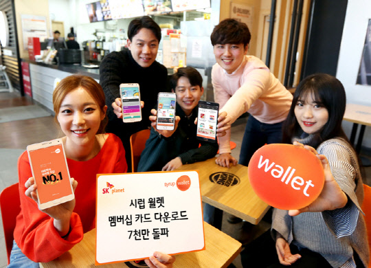 SK플래닛의 모바일 지갑 서비스 '시럽 월렛'의 멤버십 카드 내려받기 누적건수가 7000만건을 돌파했다. 모델들이 시럽 월렛의 모바일 앱을 선보이고 있다.  SK플래닛 제공